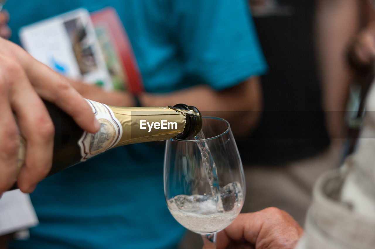 Close-up of hand pouring wine in glass