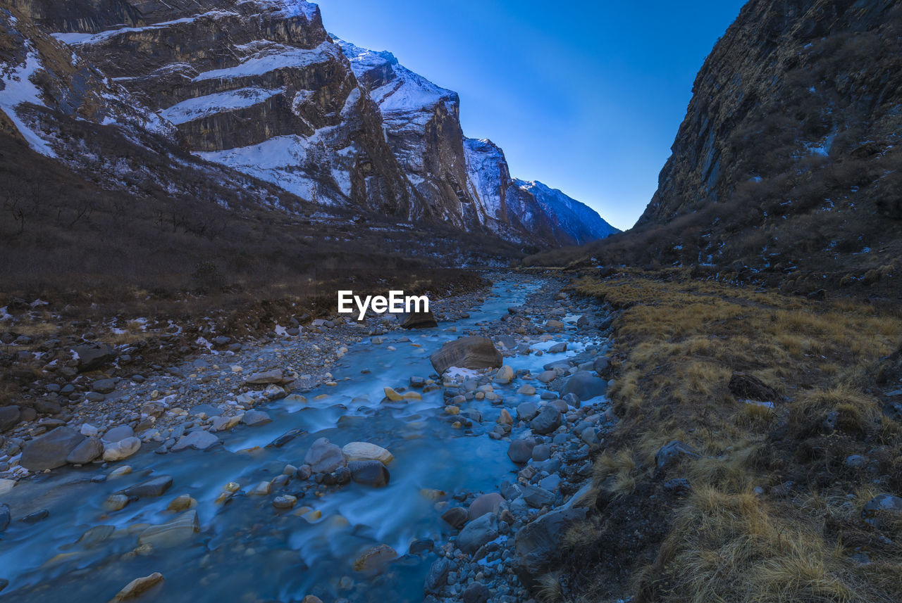 Water flowing through rocks against sky