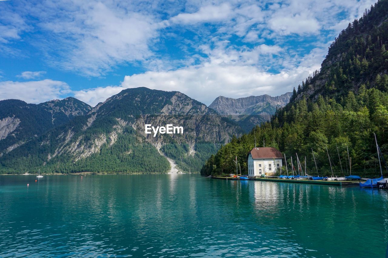 Scenic view of lake by mountains against sky