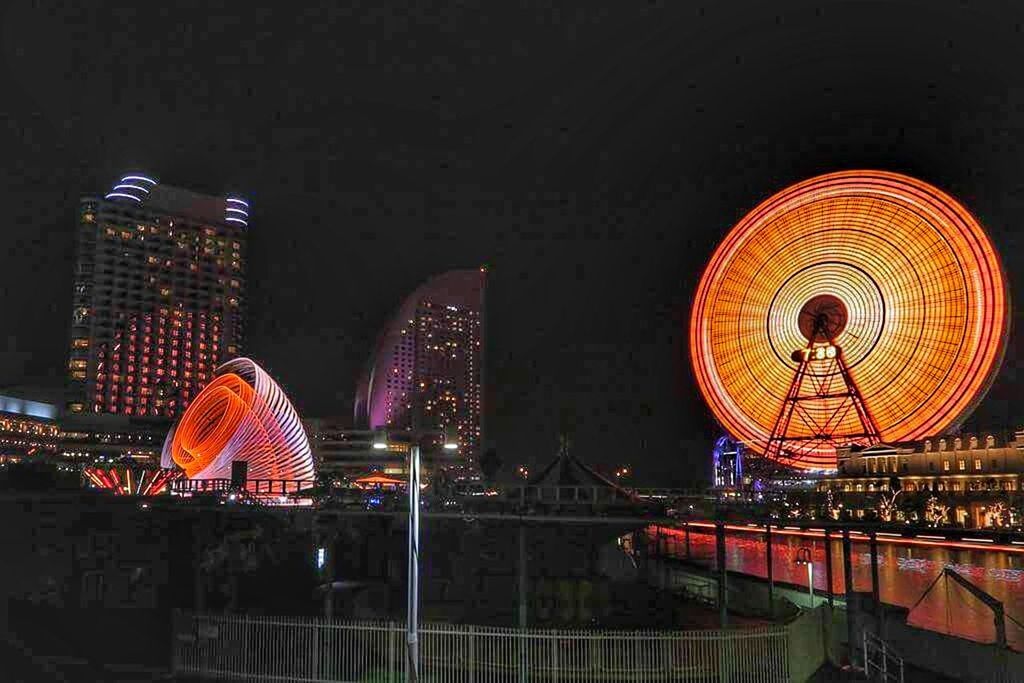 ILLUMINATED FERRIS WHEEL IN CITY AT NIGHT