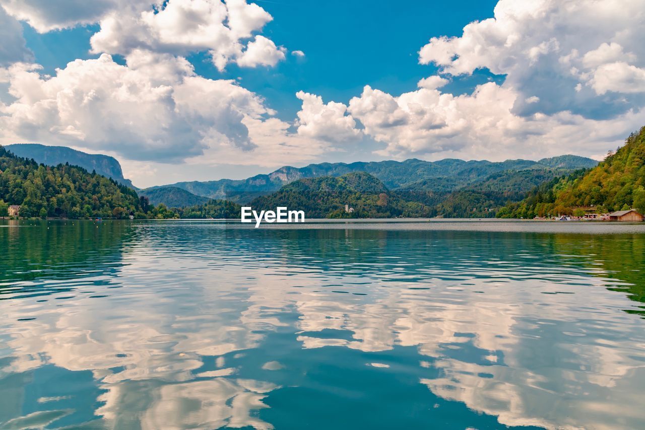 Scenic view of lake by mountains against sky