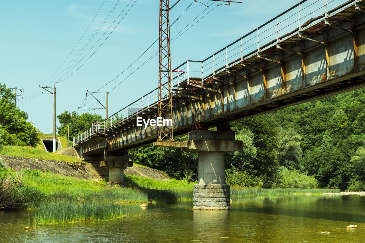 bridge, water, architecture, built structure, nature, transportation, cable, river, sky, plant, electricity, tree, no people, transport, power generation, day, outdoors, power line, reflection, electricity pylon, technology, beam bridge, waterfront, power supply, building exterior, environment, green