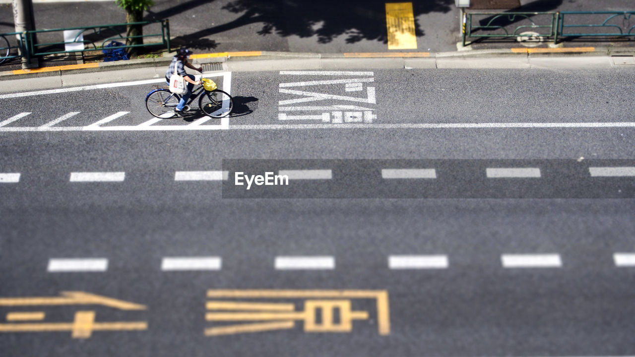 High angle view of person riding bicycle on road during sunny day