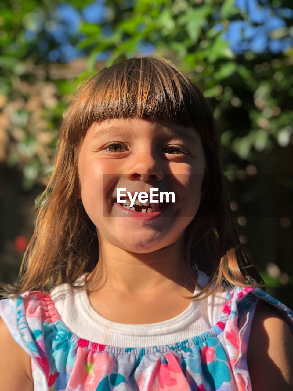 Portrait of smiling girl standing against plants