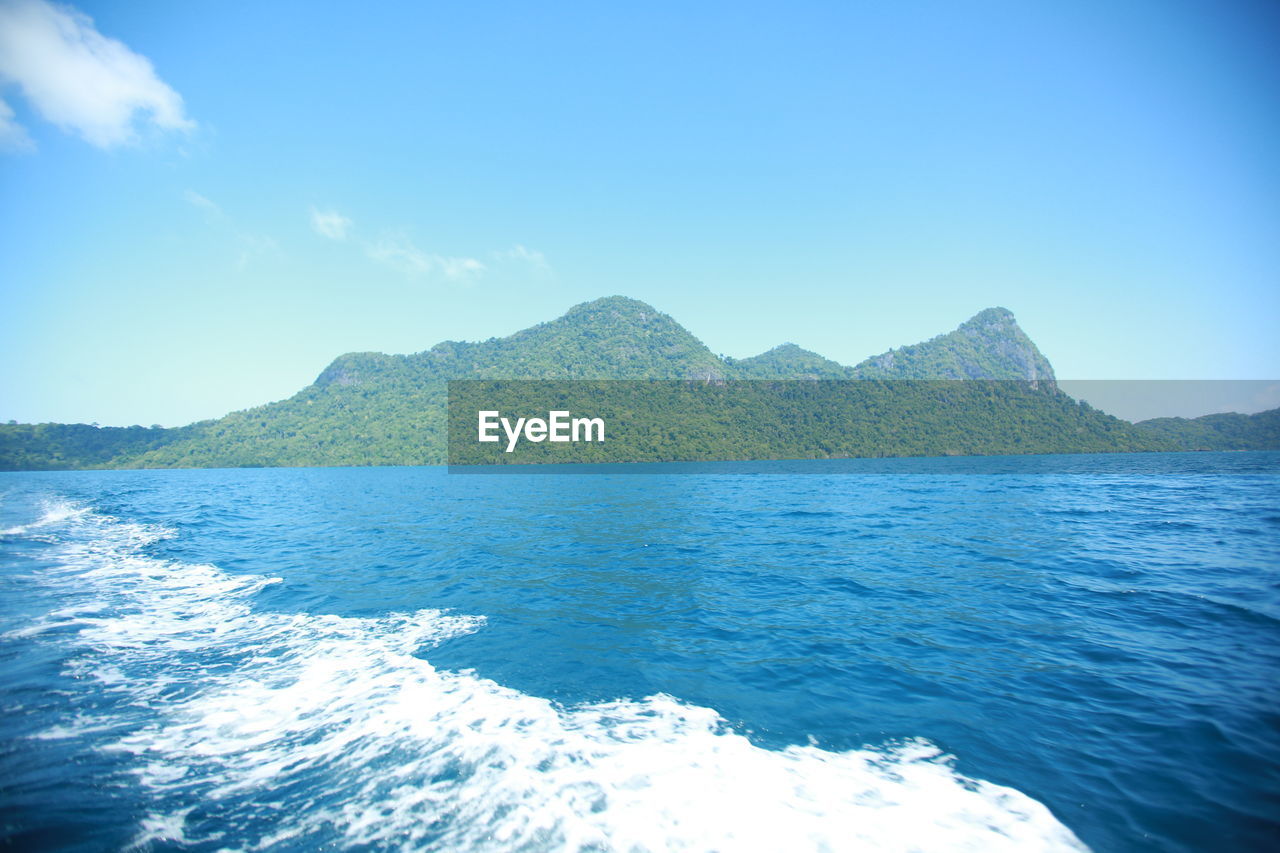 SCENIC VIEW OF SEA BY MOUNTAIN AGAINST CLEAR BLUE SKY
