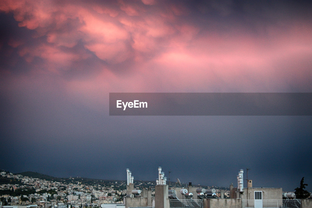 High section of city buildings against cloudy sky