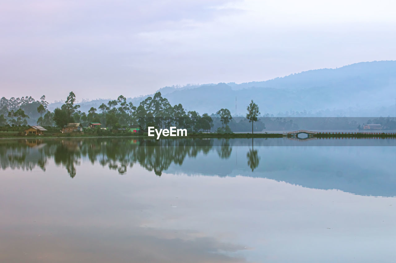 Scenic view of lake by mountains against sky