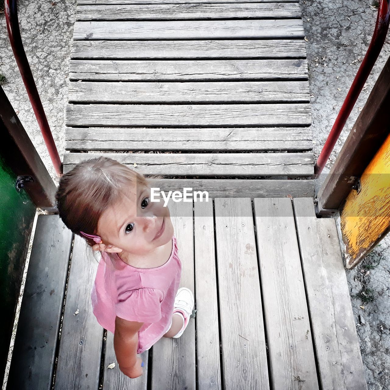 High angle view of cute girl standing on floorboard