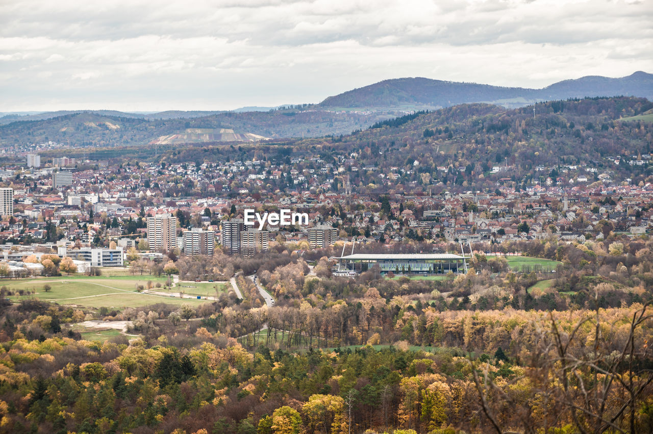 HIGH ANGLE VIEW OF TOWNSCAPE AND MOUNTAINS AGAINST SKY