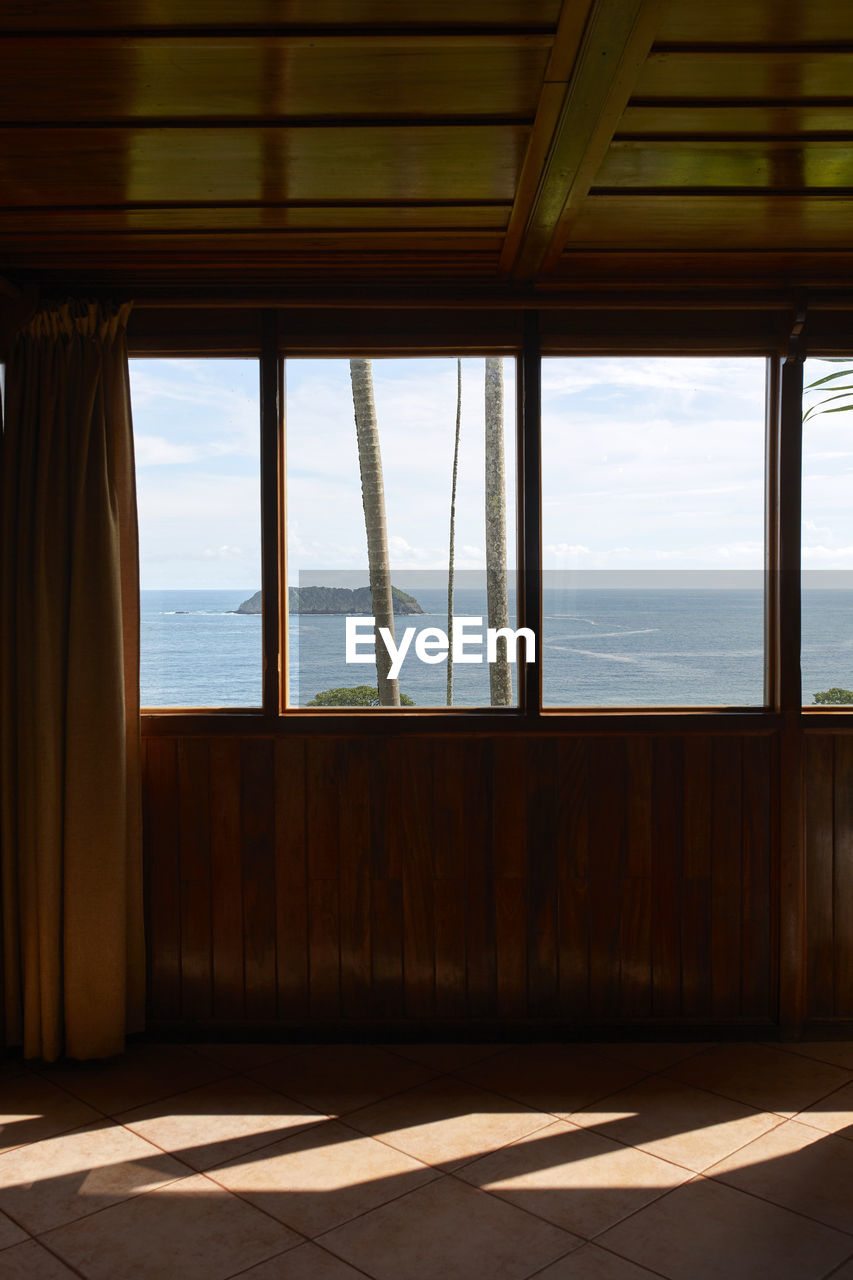 Scenic views of the sea from inside the wooden bedroom through the windows