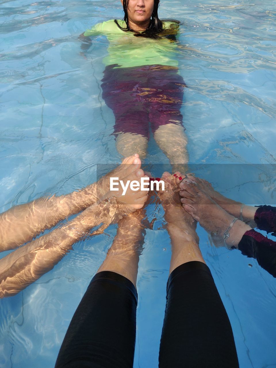LOW SECTION OF PEOPLE ON SWIMMING POOL