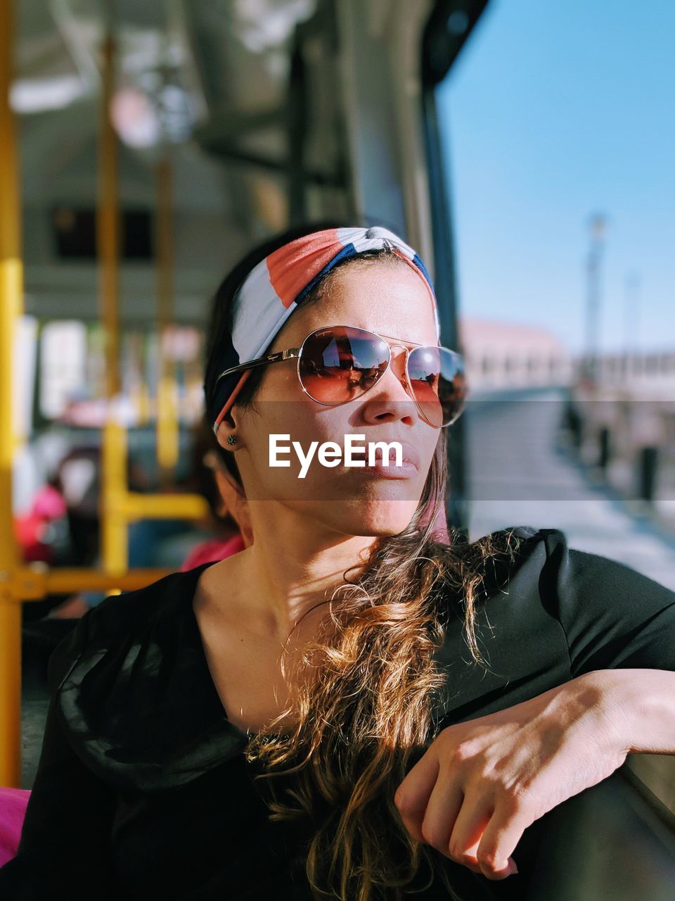 Woman wearing sunglasses while sitting in bus