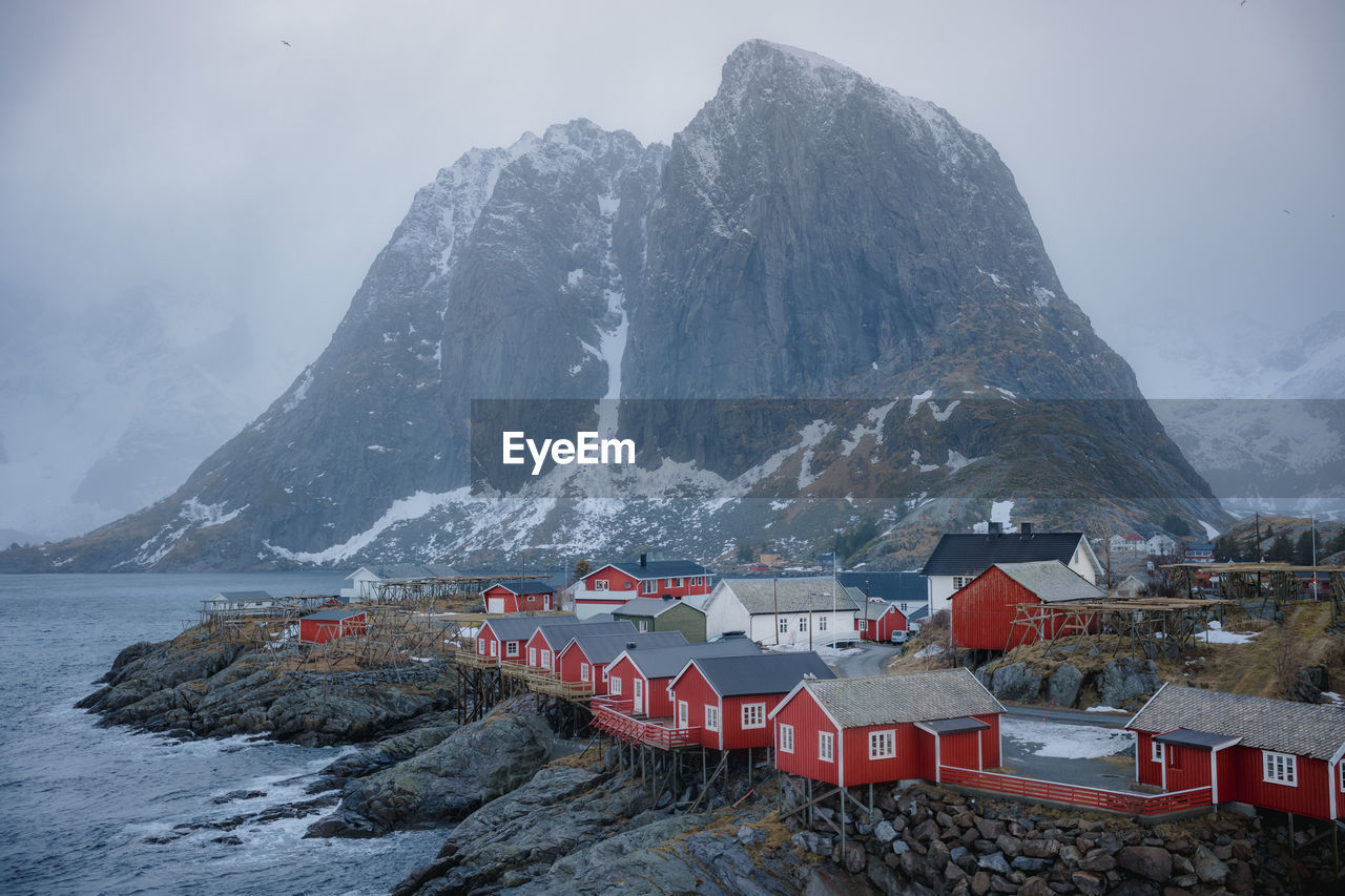 View of red houses next to the ocean in a norwegian fjord in lofoten