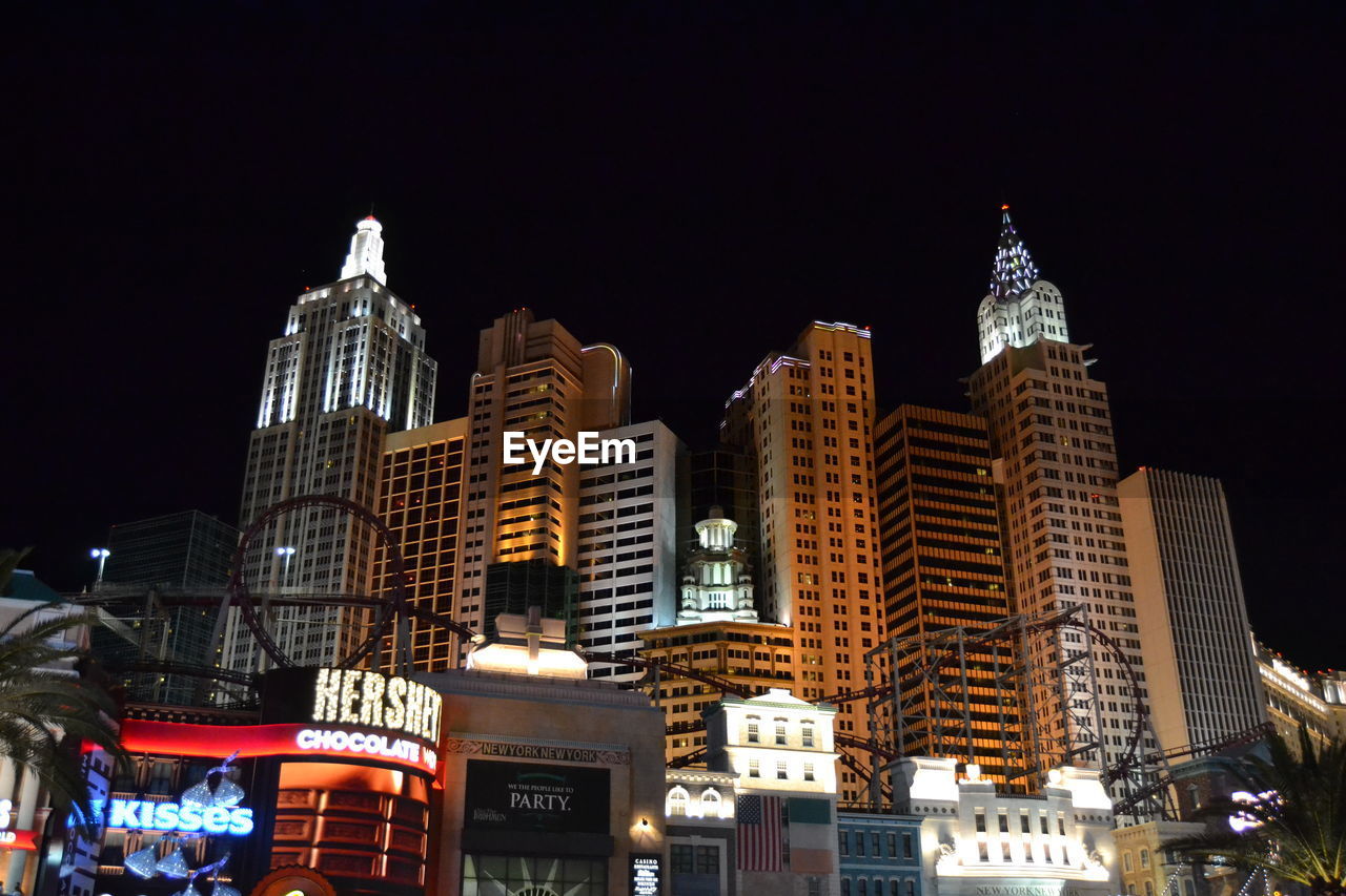 LOW ANGLE VIEW OF ILLUMINATED CITYSCAPE AGAINST SKY