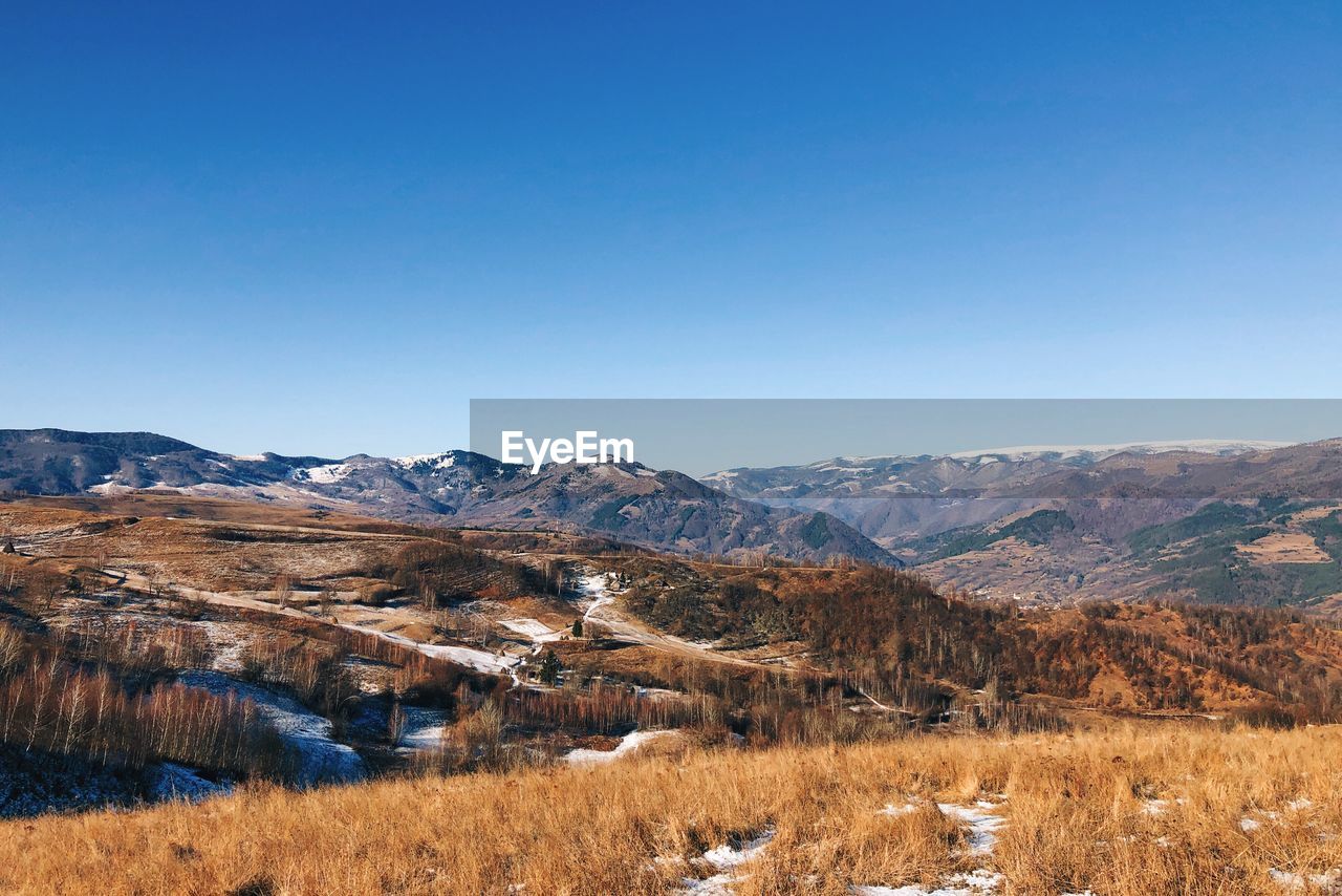 Scenic view of mountains against clear blue sky