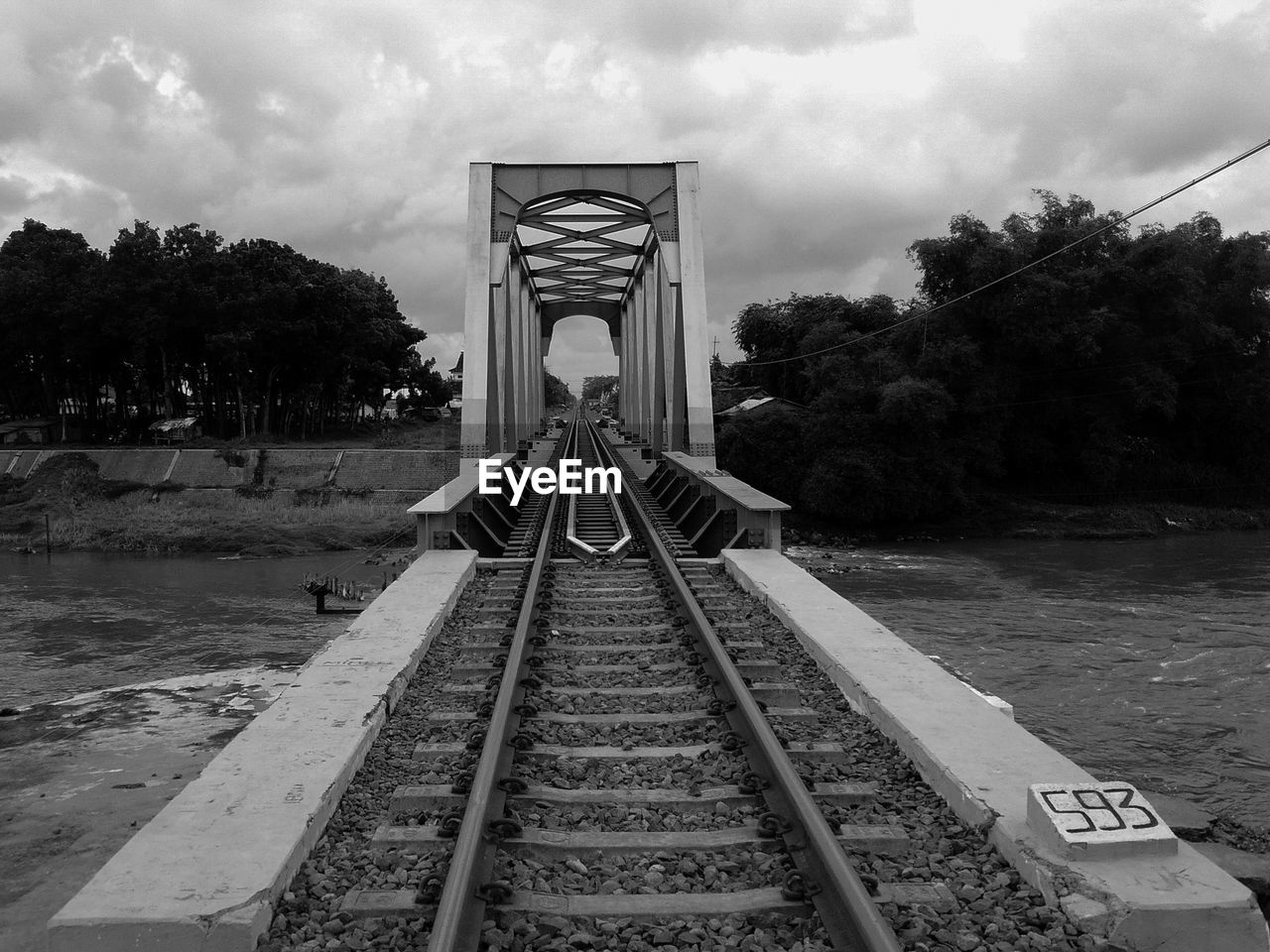 Railroad tracks by trees against sky