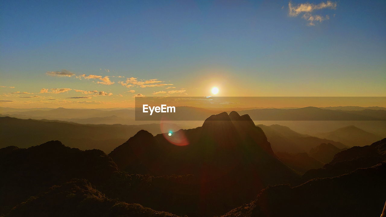 Scenic view of silhouette mountains against sky during sunset