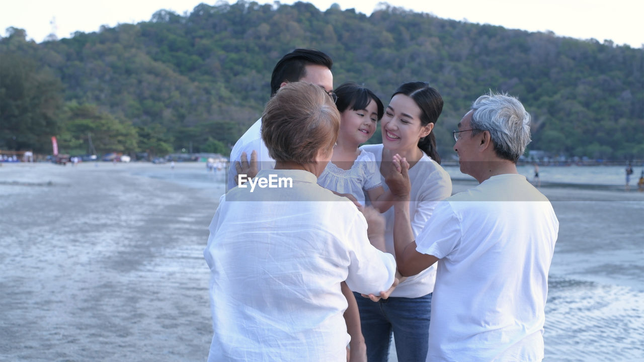 FRIENDS STANDING ON BEACH