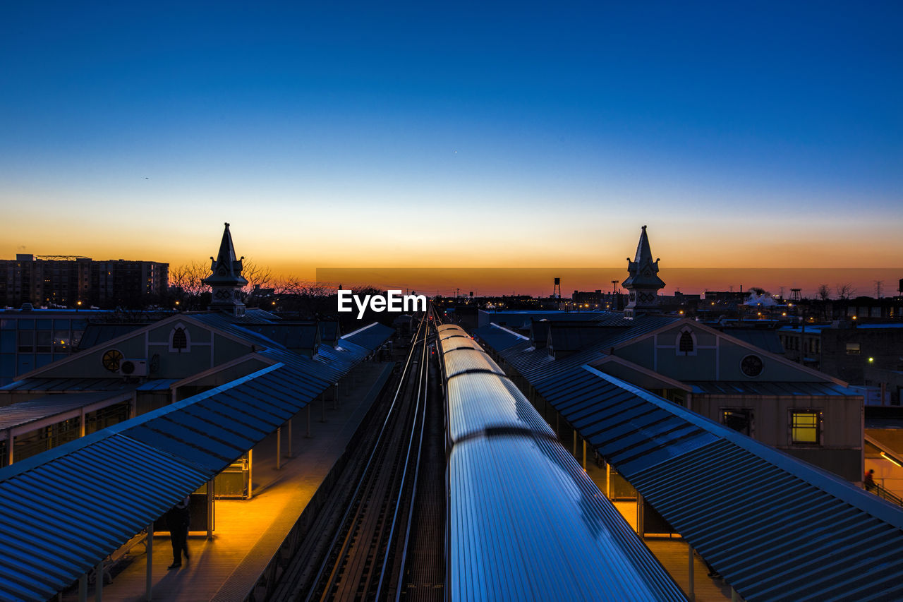 High angle view of train at illuminated railroad station against sky