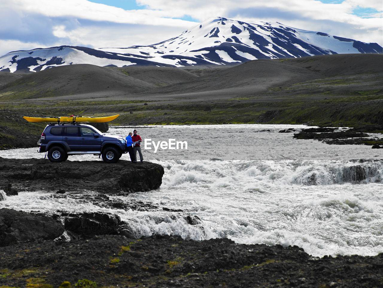 Couple reading map in front of their customised suv in iceland