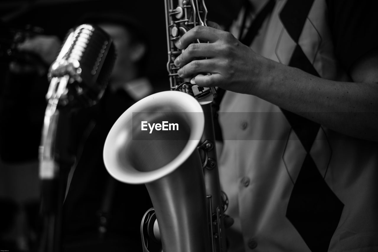 Midsection of man playing saxophone during concert