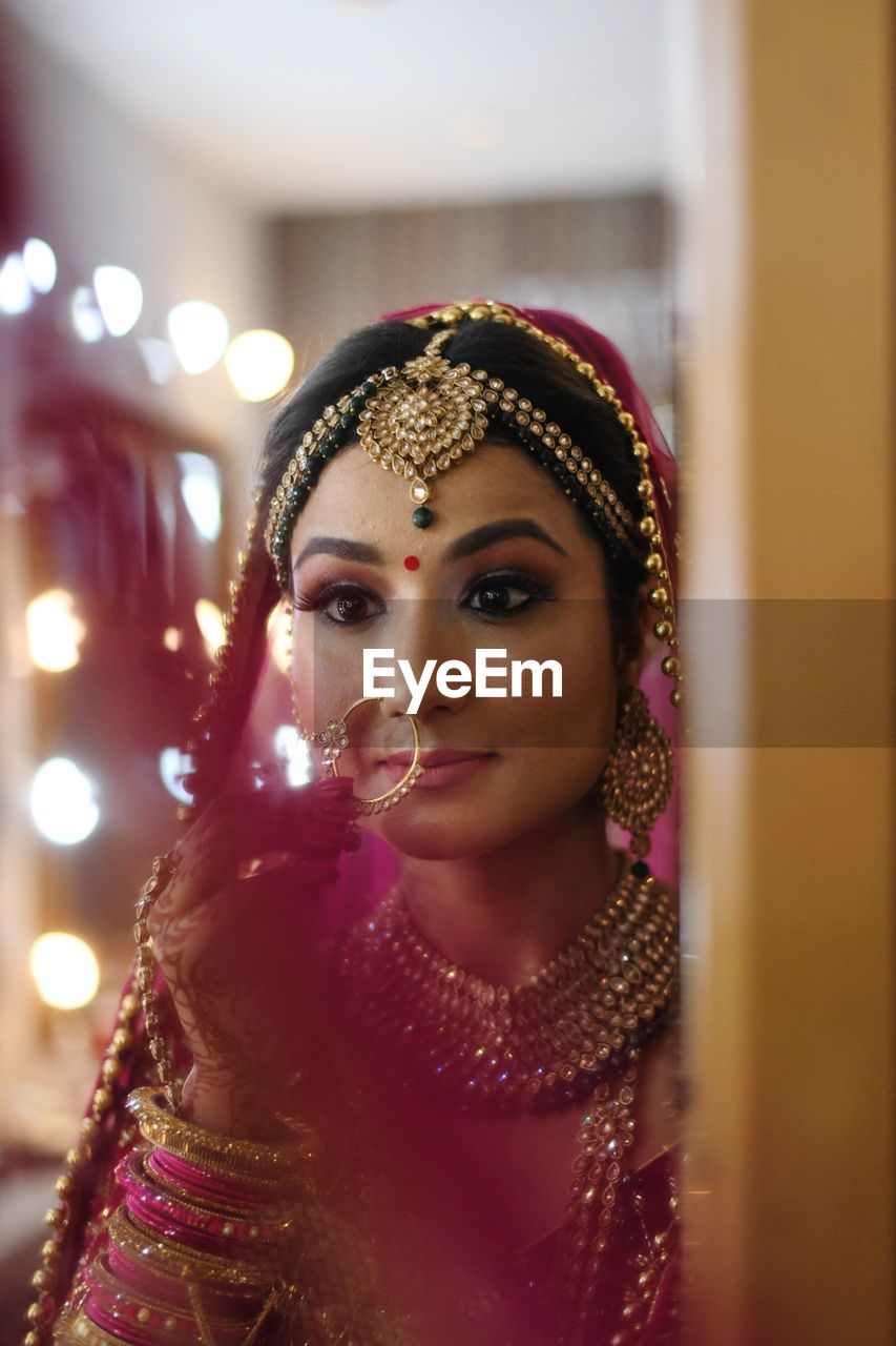 Bride looking at mirror during wedding ceremony