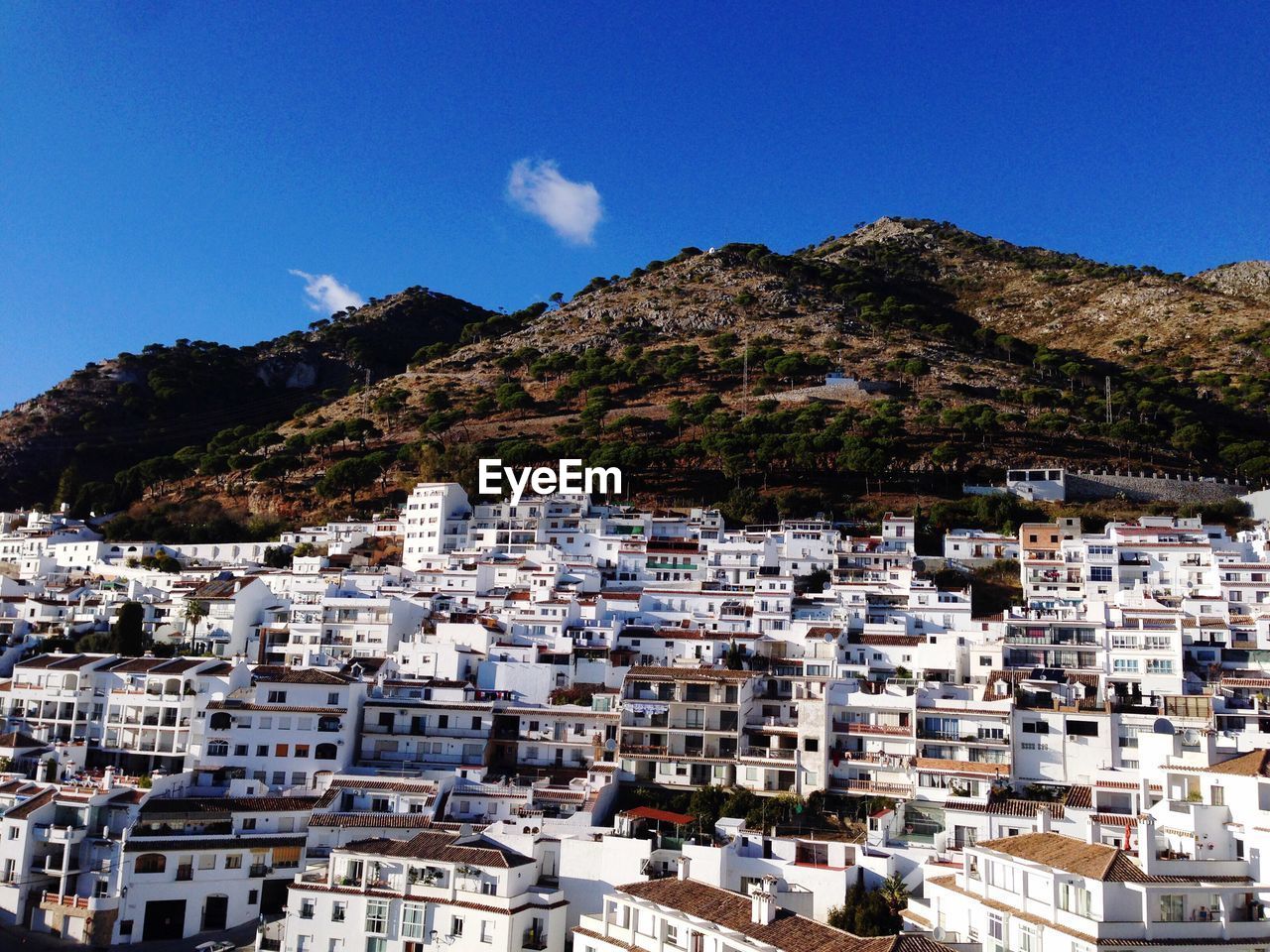 Houses in town against clear blue sky