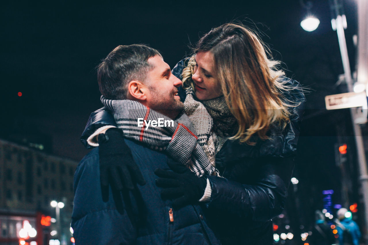 YOUNG COUPLE IN ILLUMINATED PARK DURING WINTER