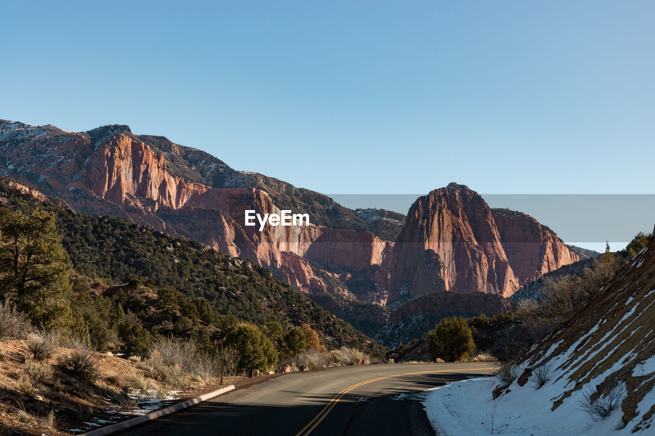 Road by mountain against clear sky