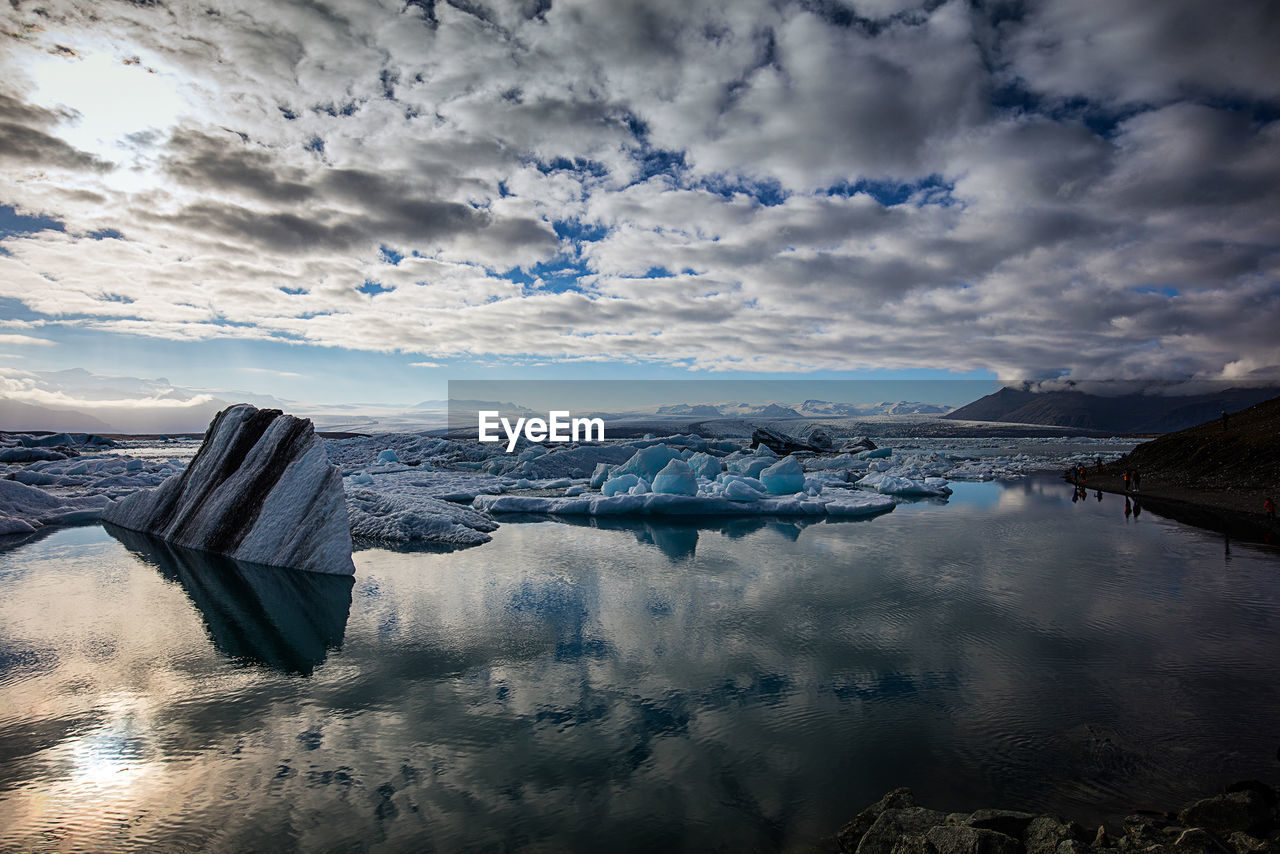 Scenic view of glacier lagoon against cloudy sky