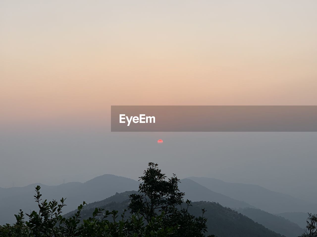 SILHOUETTE TREES AND MOUNTAINS AGAINST SKY DURING SUNSET