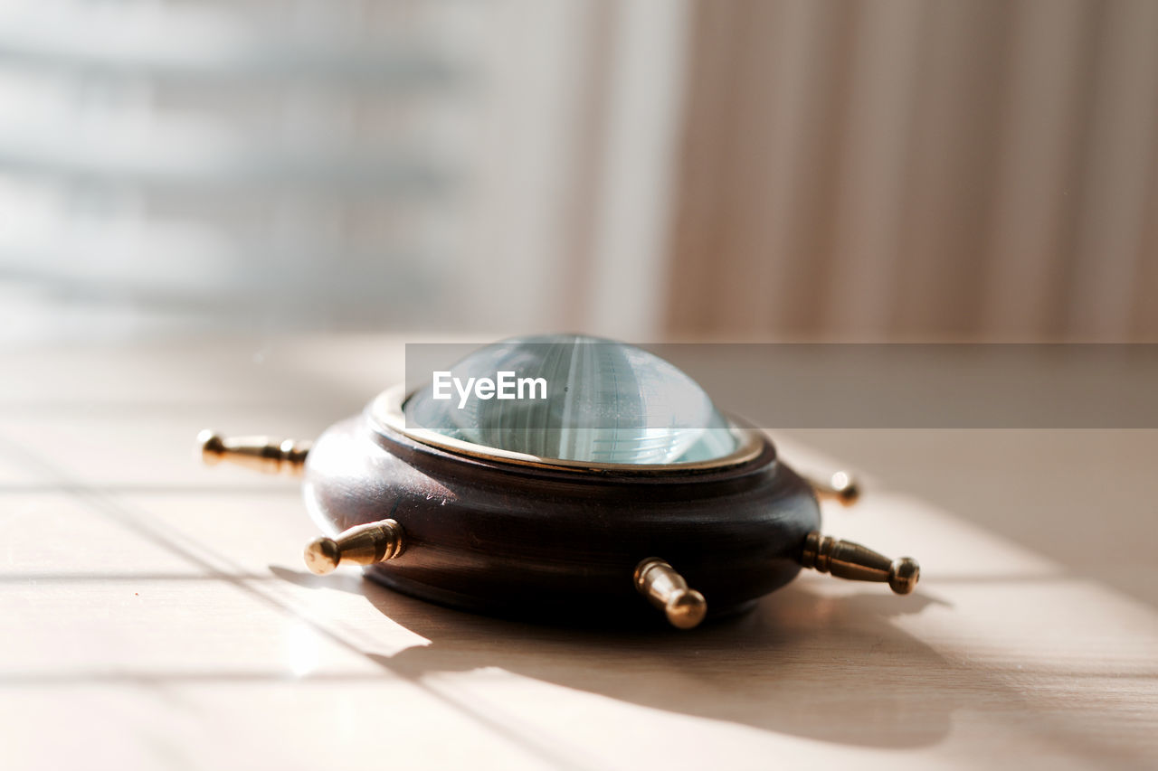 Close-up of navigational compass on floor at home