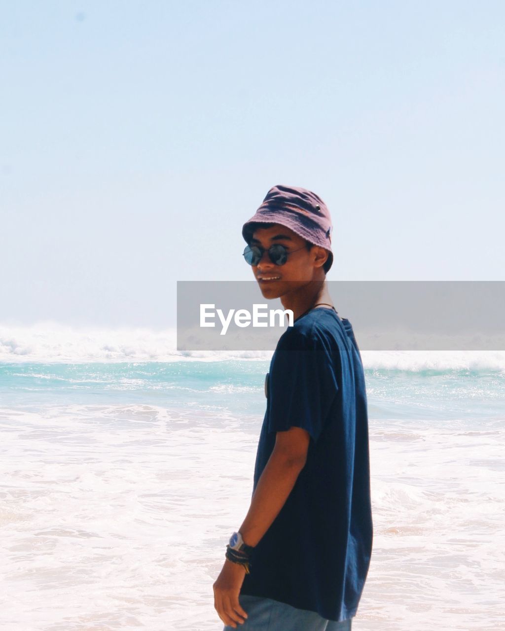 Man wearing sunglasses while standing in sea against sky