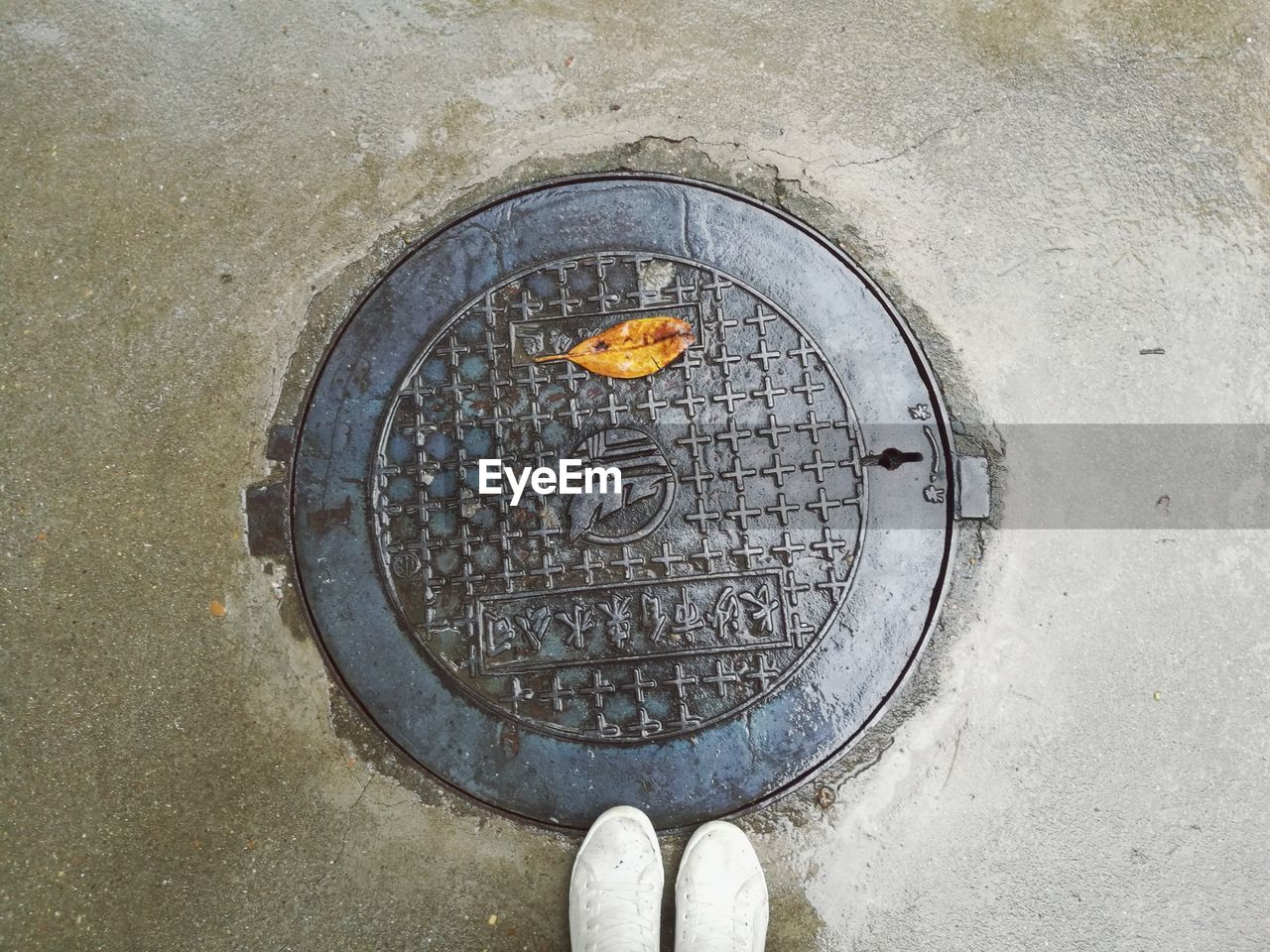 LOW SECTION OF PERSON STANDING IN MANHOLE