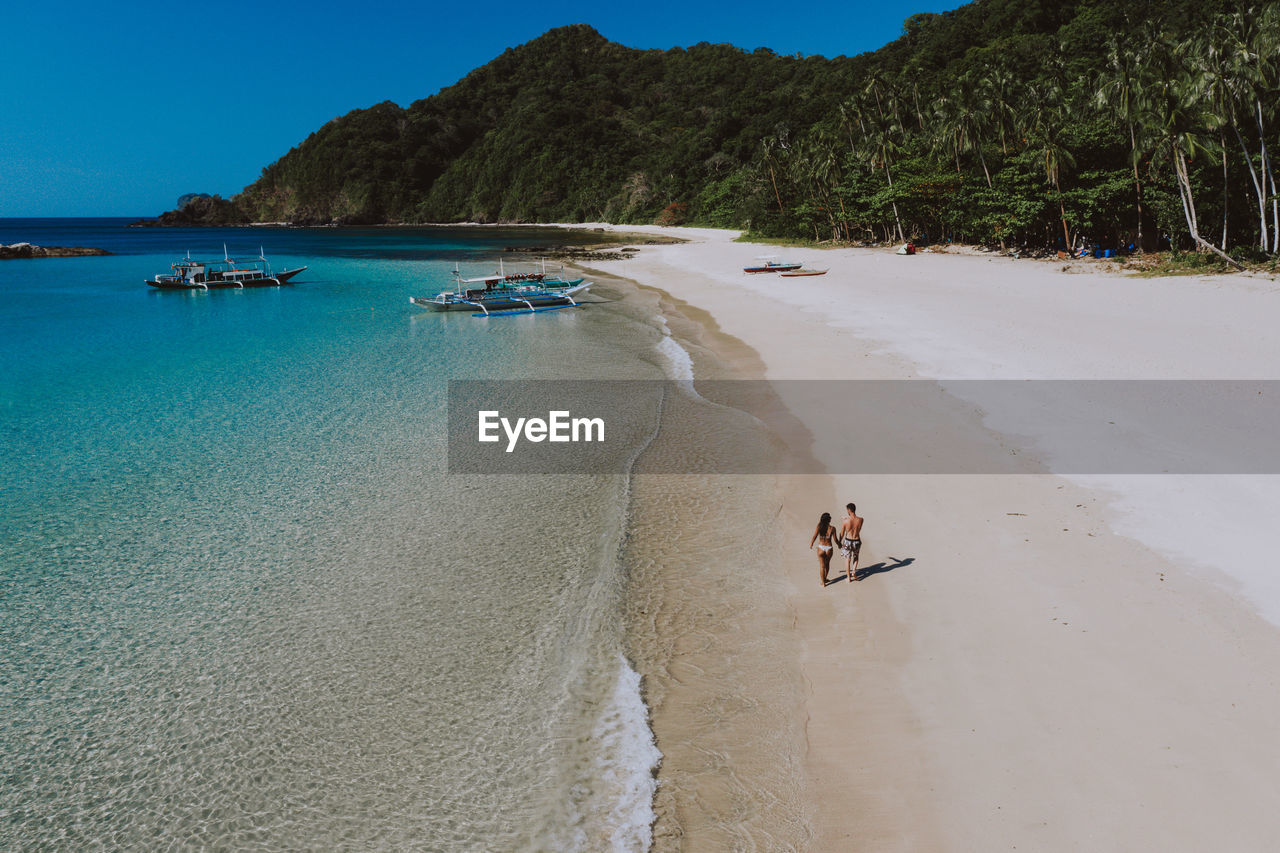 Drone view of couple at beach on sunny day