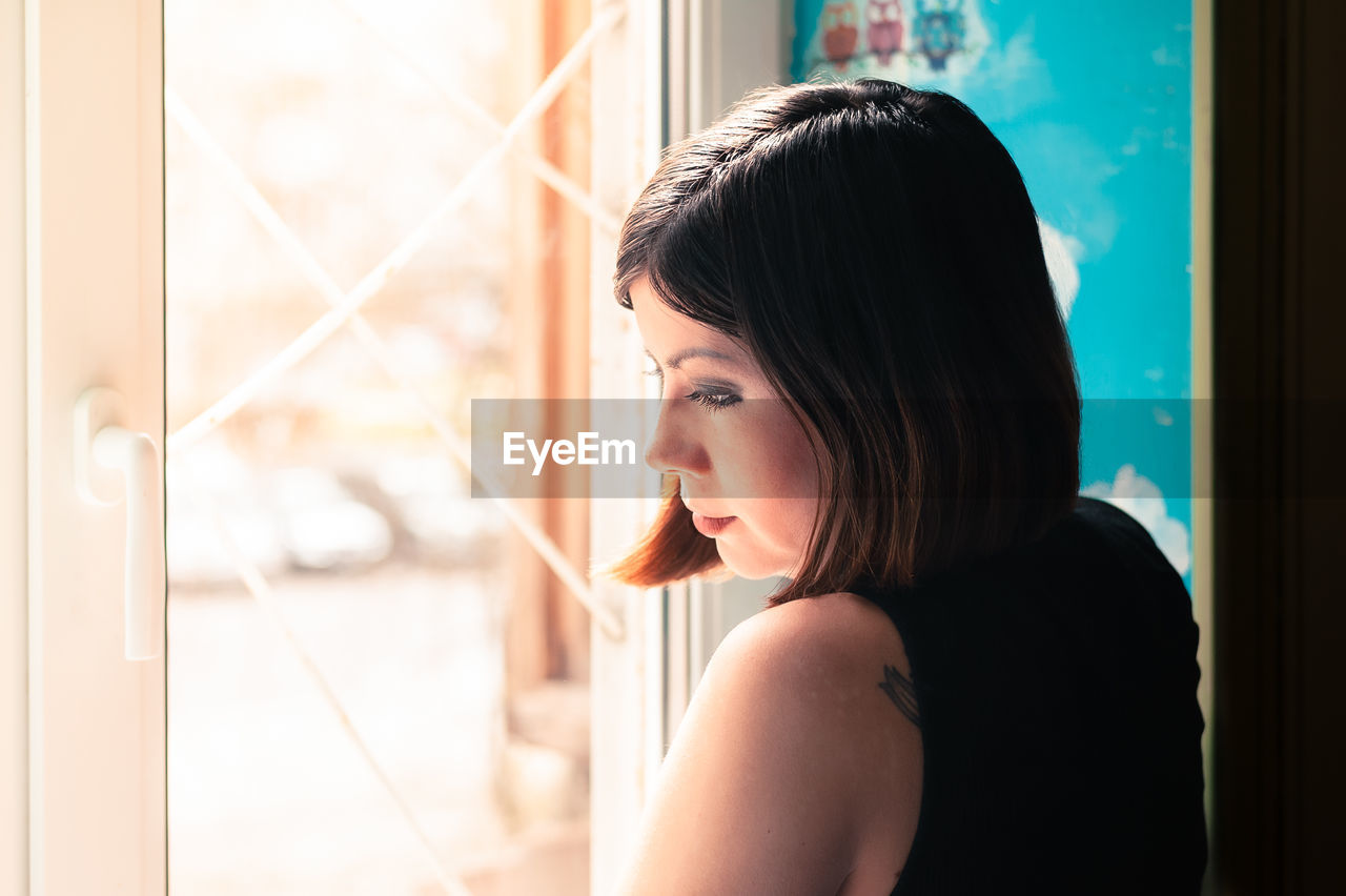 Portrait of young woman looking away at home