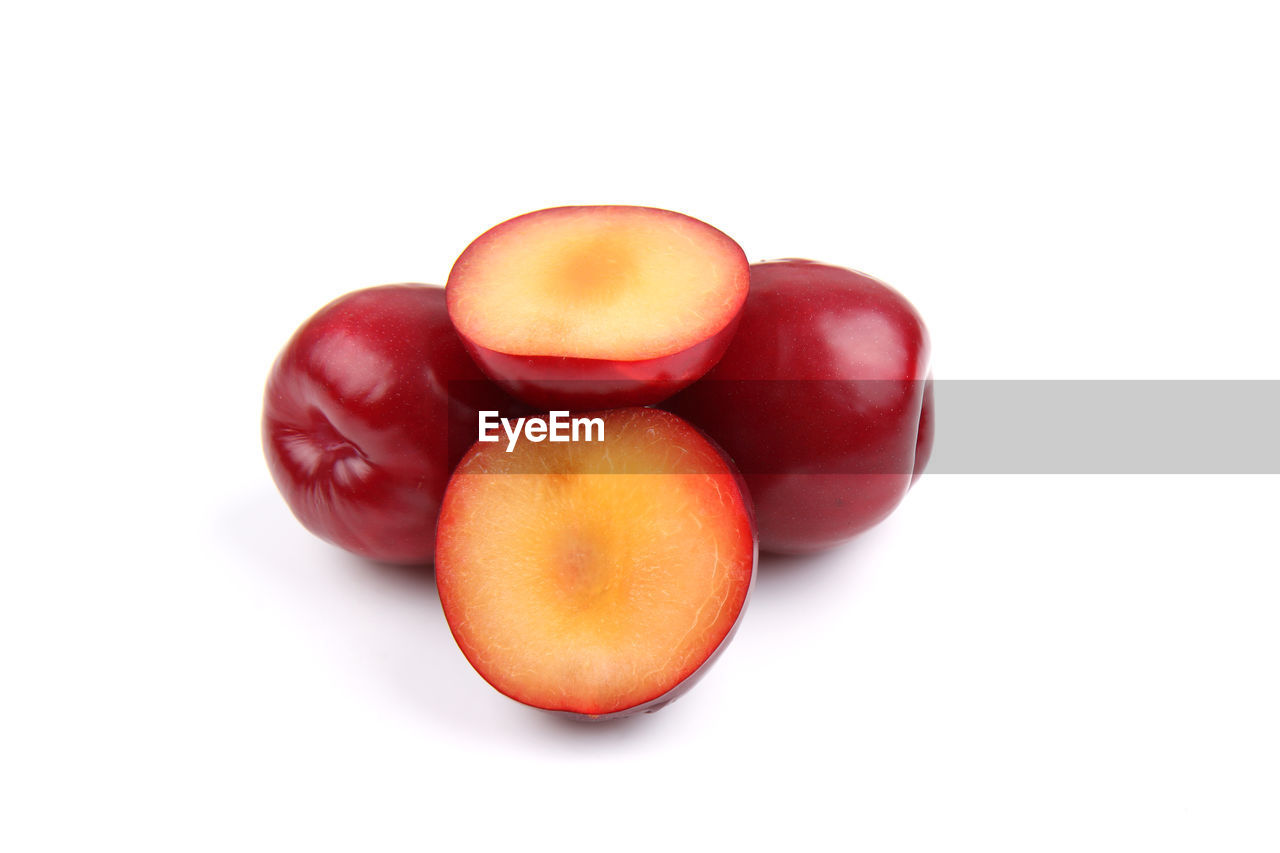 CLOSE-UP OF TOMATOES AGAINST WHITE BACKGROUND