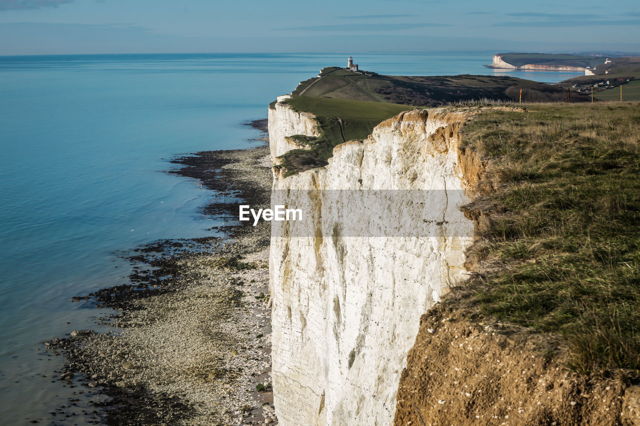 ROCK FORMATIONS ON SHORE AGAINST SKY