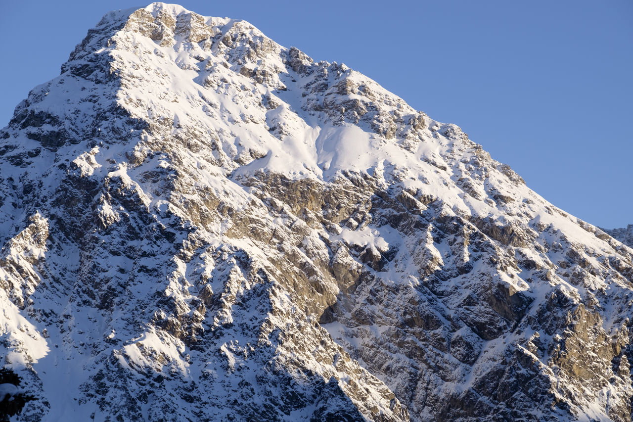 Low angle view of snow covered mountain against sky