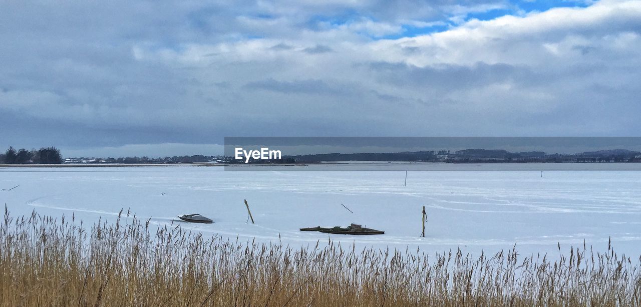 Scenic view of lake against cloudy sky