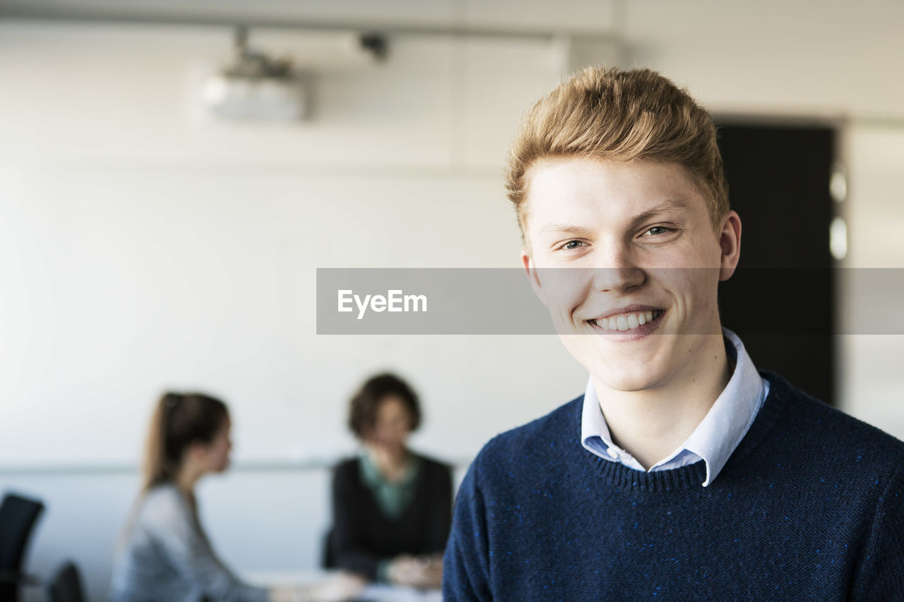 Portrait of happy young man in classroom