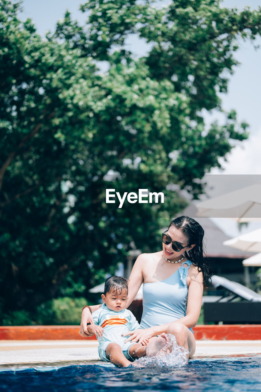 Full length of mother with son sitting outdoors