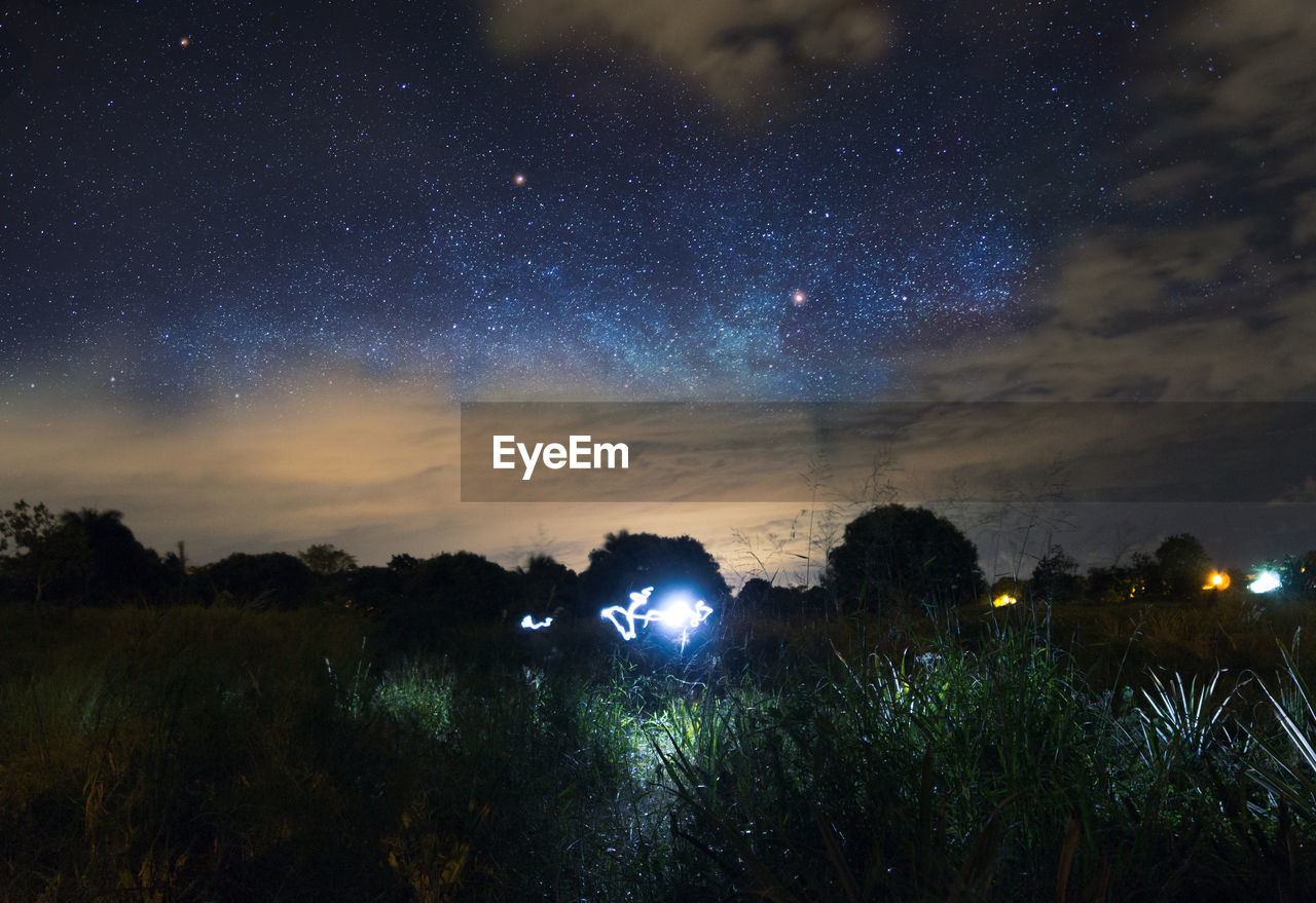 ILLUMINATED FIELD AGAINST SKY AT NIGHT