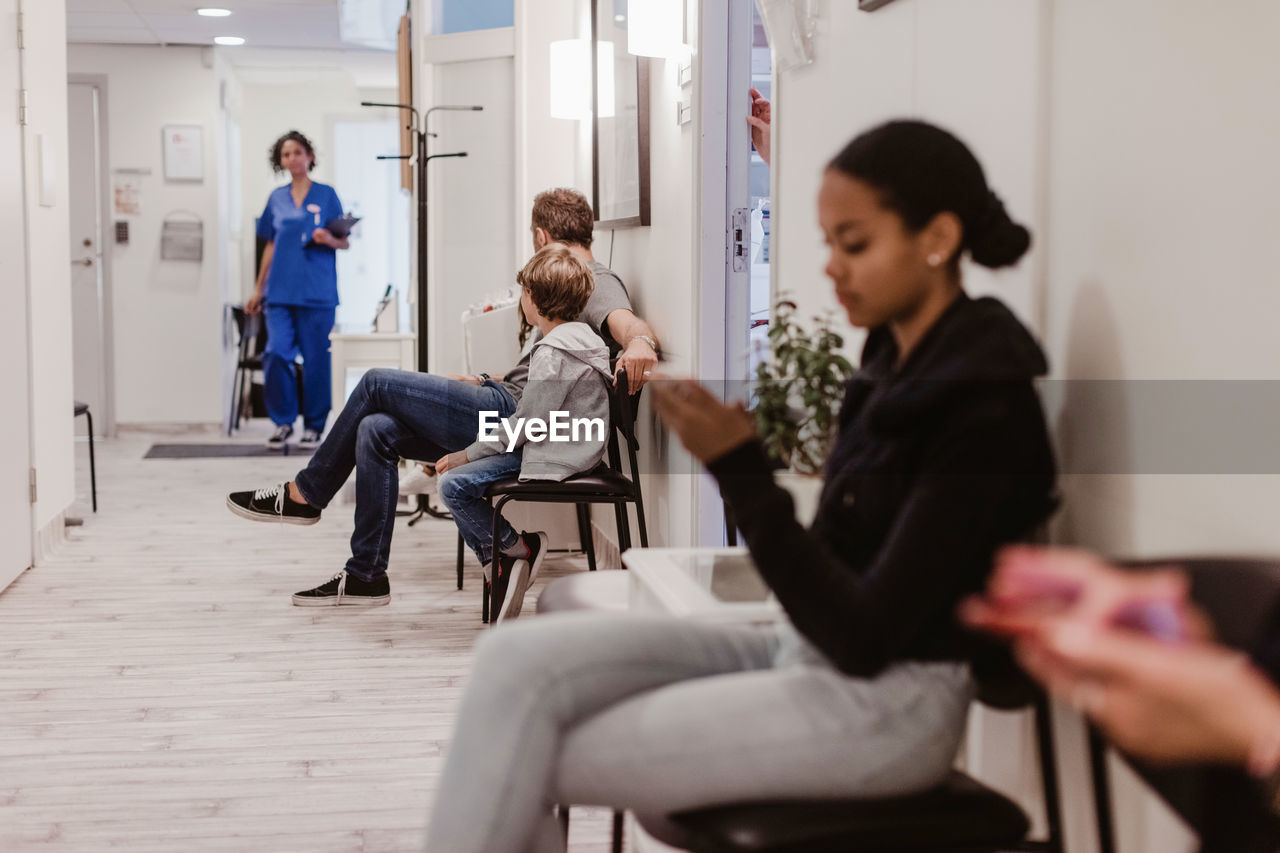 Male and female patients waiting in corridor of hospital