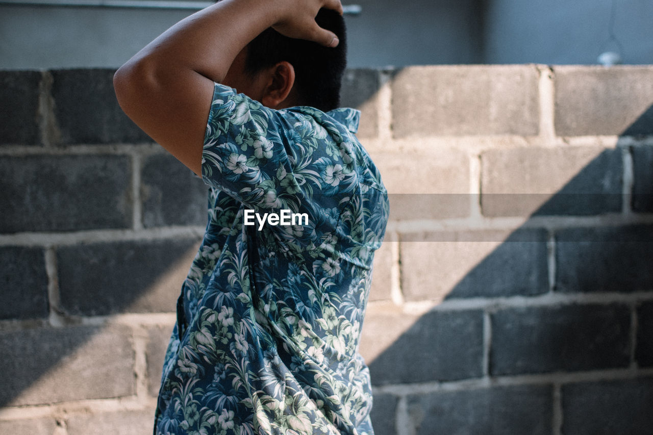 blue, one person, dress, wall, fashion, architecture, wall - building feature, brick wall, brick, clothing, adult, spring, women, standing, photo shoot, black, day, person, lifestyles, city, young adult, outdoors, staircase, casual clothing, built structure