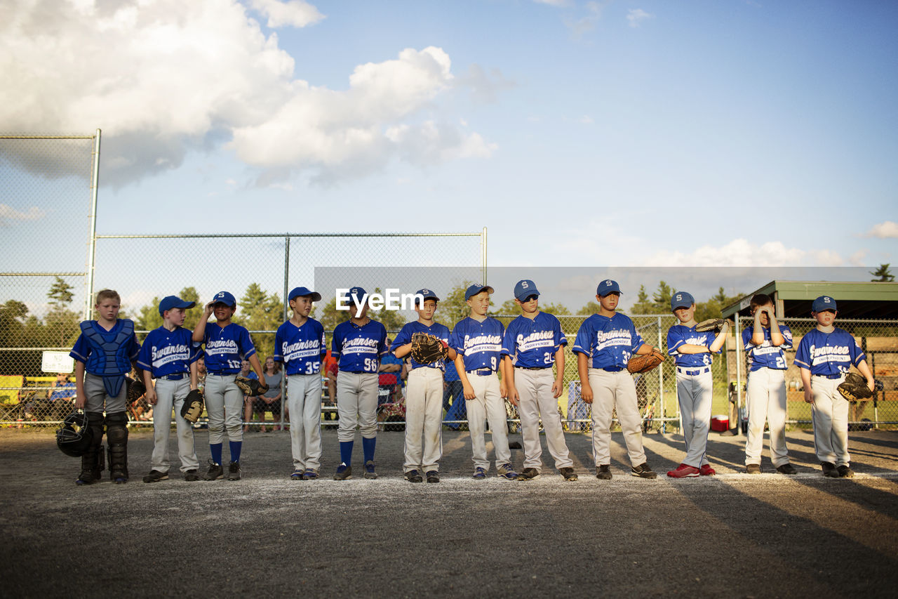 Baseball team standing on field against sky