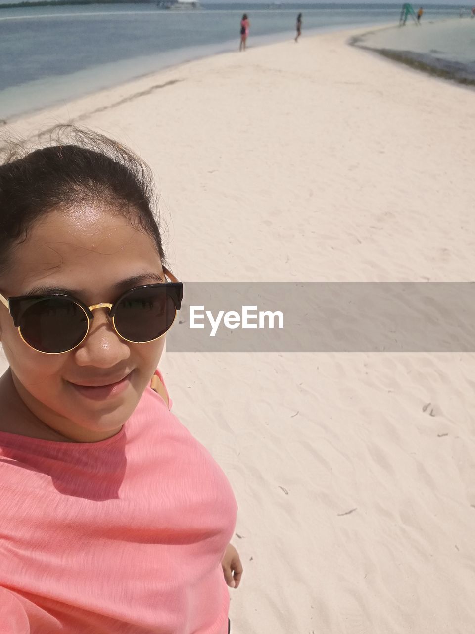 CLOSE-UP PORTRAIT OF HAPPY GIRL ON BEACH