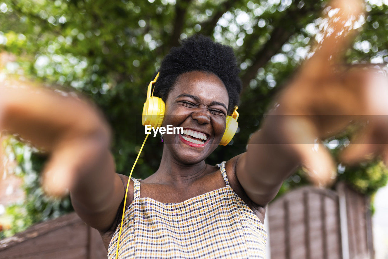 Cheerful woman listening to music through headphones