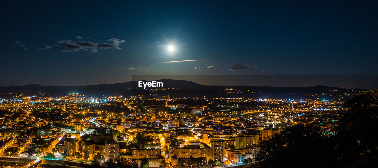 High angle view of illuminated cityscape against sky at night