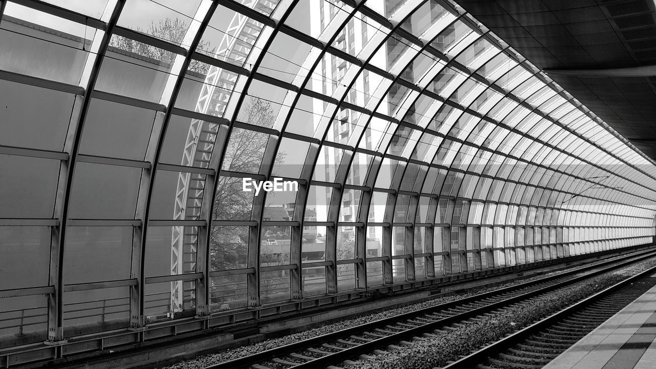 Railway tracks by glass wall